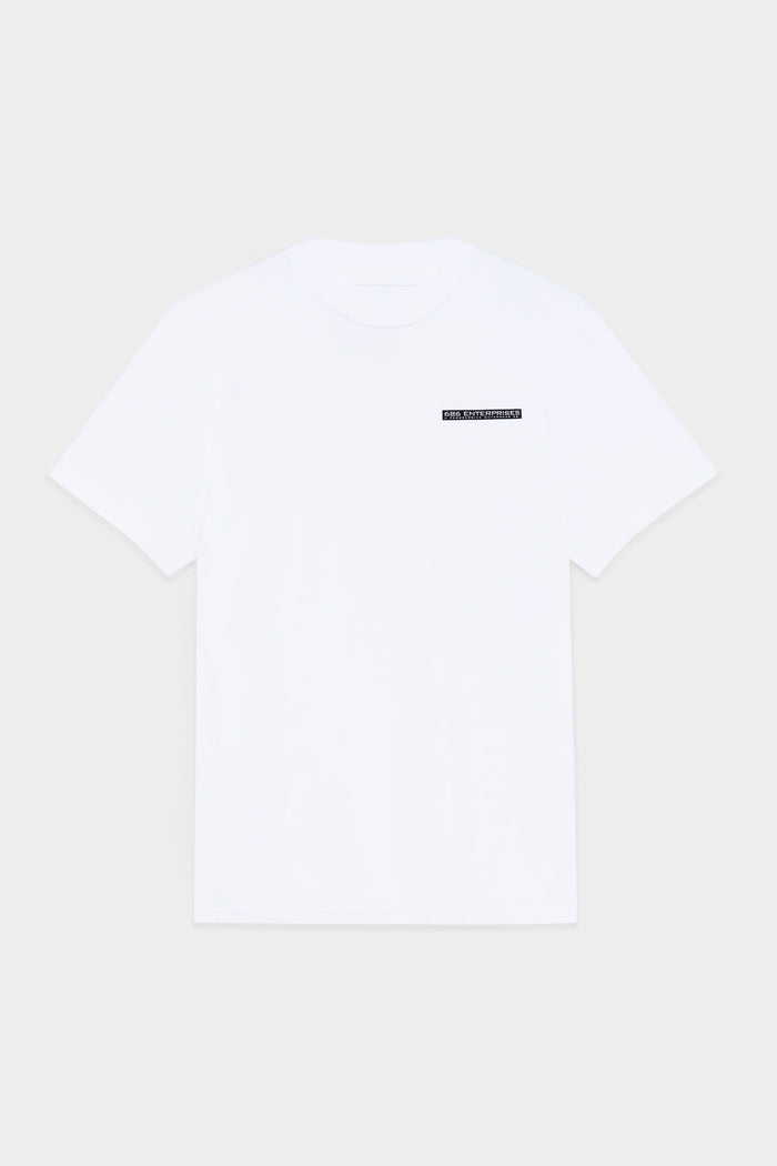 The 686 Mens Global Enterprises Short Sleeve Tee by 686 features a plain white design with a small black rectangular retro logo and white text on the upper left chest, shown on a light grey background.