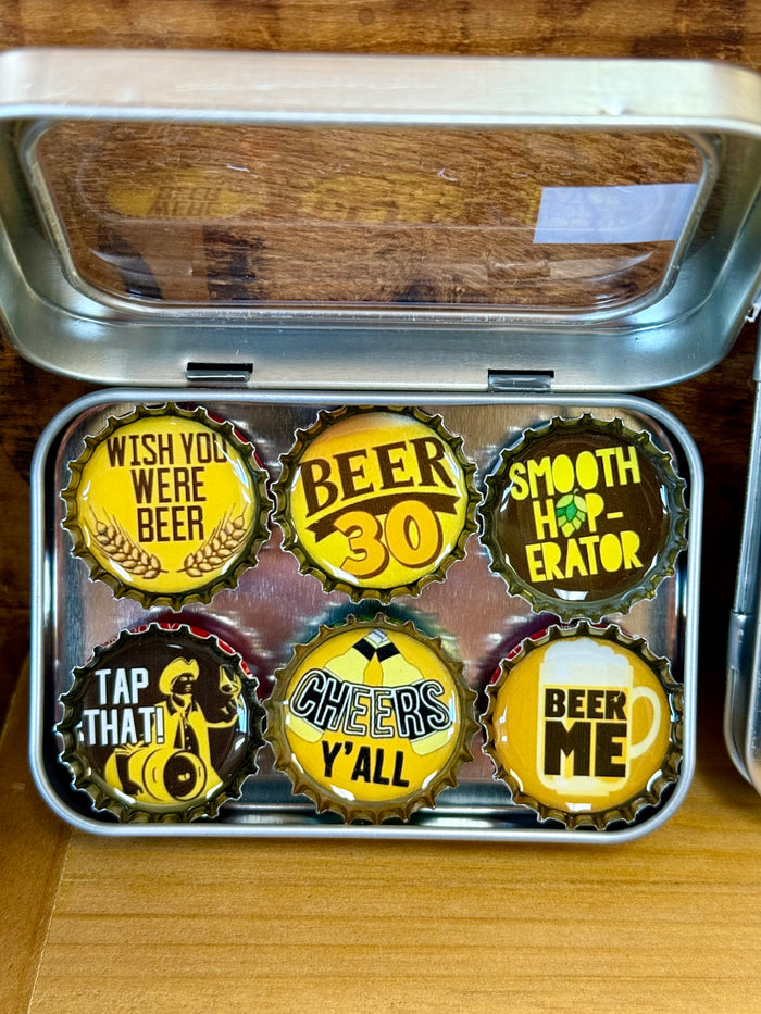 Handmade beer magnets set in open metal tin, six bottle-cap magnets with bold phrases