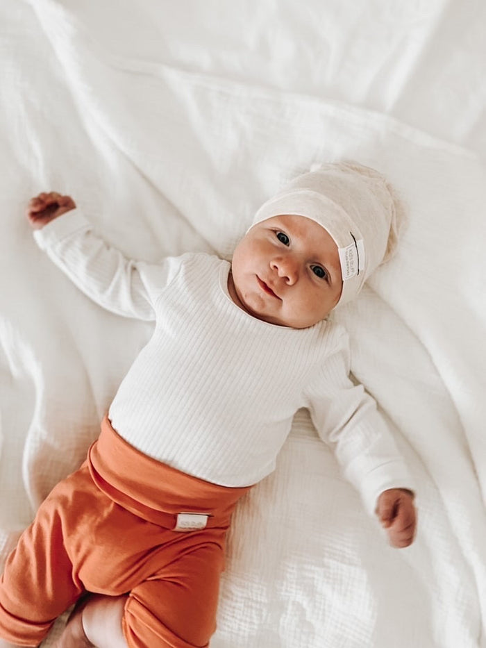 Soft and stretchy Heather cream beanie for kids, made from eco-friendly fabric. Ethically crafted in Canada, featuring a fold-over brim and minimalist design