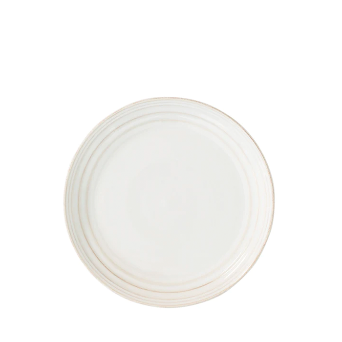 A white ceramic salad plate with a gold rim.