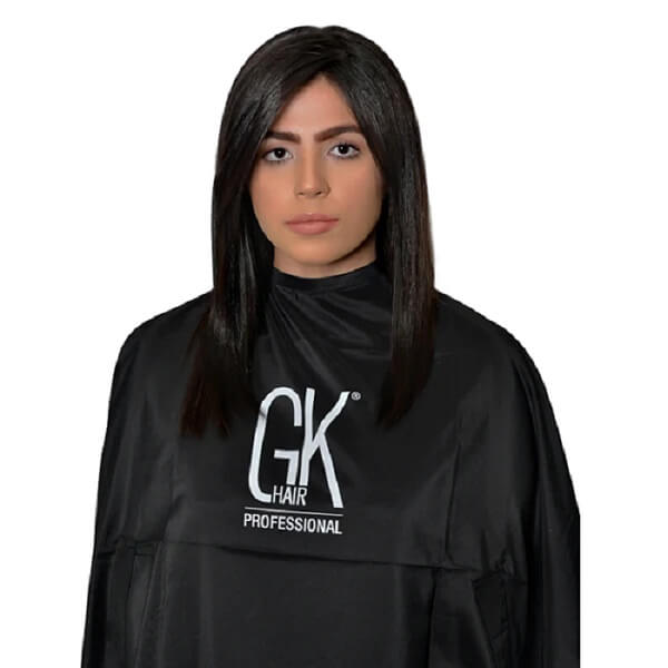 GK Hair Professional black salon cape with a white logo, worn by a dark-haired model on a white background