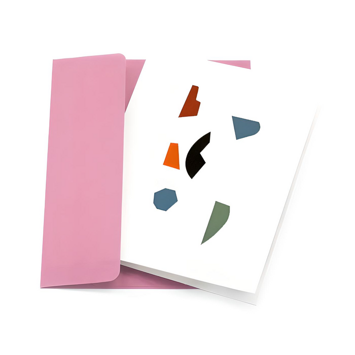 Minimalist greeting card with colorful abstract geometric shapes on a white cover, paired with a soft pink envelope in a clean modern stationery presentation.