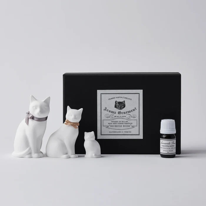 White cat-shaped aroma ornament gift set with three ceramic cat figures in different sizes, essential oil bottle, and black vintage-style box, displayed on a clean white background in a minimalist home fragrance product presentation.