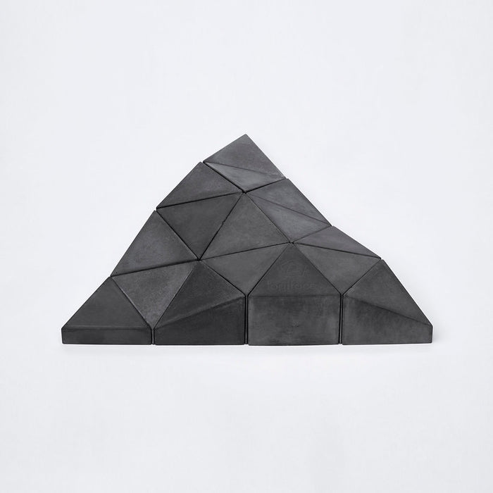 Logifaces, a geometric puzzle made of concrete triangular prisms, arranged in various configurations to form a continuous surface. The minimalist design encourages creative problem-solving and spatial thinking