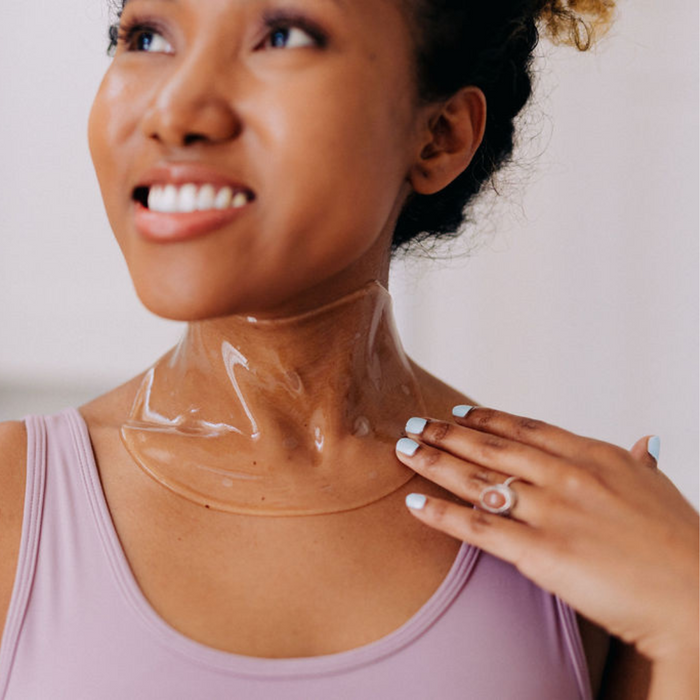 woman of color wearing Frownies Apple Serum Neck Mask made of cactus collagen for horizontal neck lines