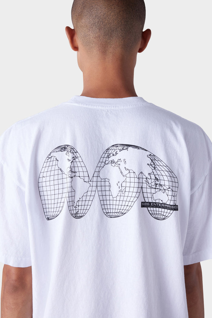 A person wears the 686 Mens Global Enterprises Short Sleeve Tee‚Äîfeaturing a black abstract world map and GSG ENTERPRISE text on the back‚Äîstyled from behind. The vintage-fit white shirt by 686 pops against a plain, light background.