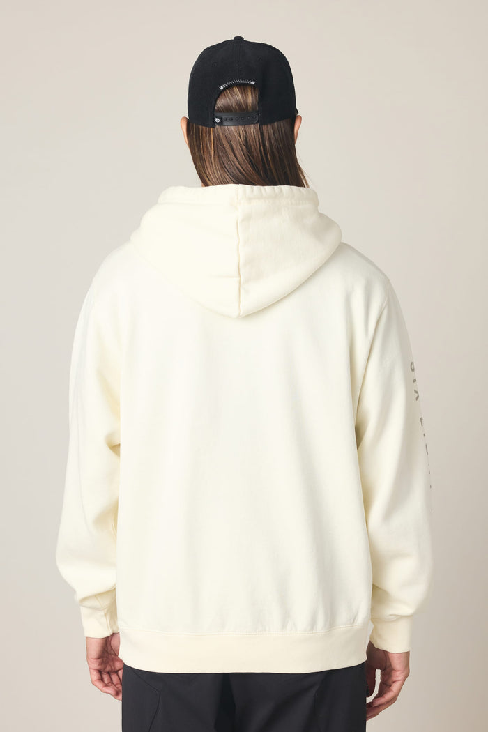 A person is shown from the back against a plain light background, wearing the 686 Men's High Def Relaxed LS Hoody in cream and a black baseball cap. Their long, straight hair is visible below the cap.