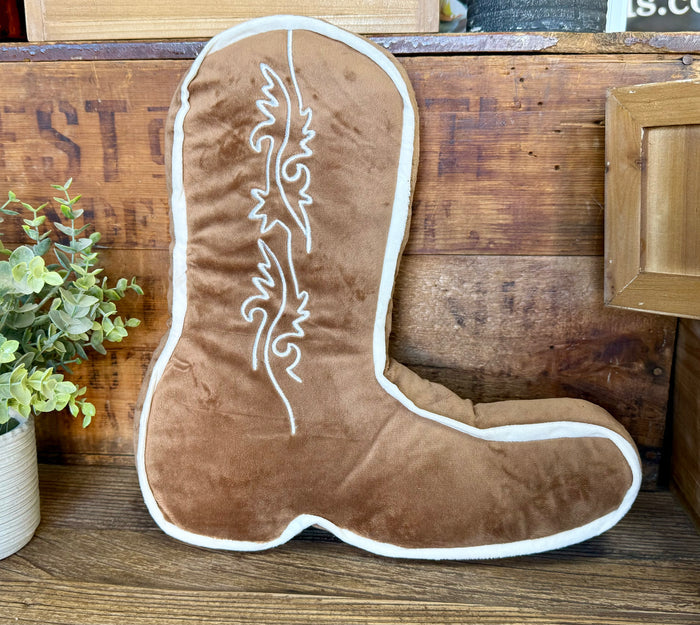 Tan cowboy boot-shaped pillow with white outline and embroidered boot design
