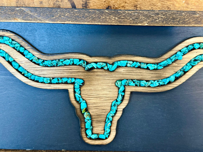 Close-up of turquoise longhorn design with textured string lines on blue board