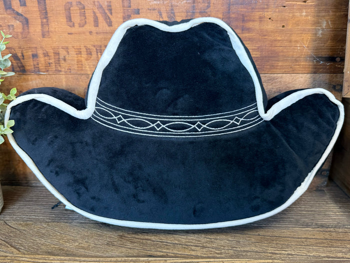 Dark cowboy hat-shaped pillow, white outline trim, decorative stitch across brim