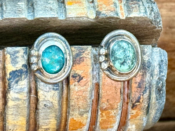Sterling silver turquoise stud earrings close-up, round turquoise cabochons in oval bezels