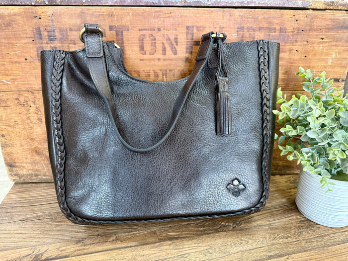 Dark brown leather tote bag with braided trim, top handles, and decorative logo on front