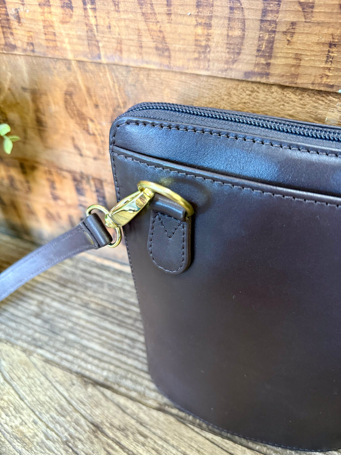 Brown leather purse corner with gold D-ring and stitched handle strap attachment