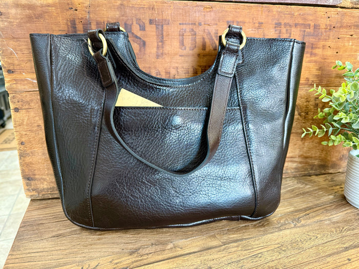 Dark brown leather tote bag with wide strap, braided trim, and metal ring handle hardware