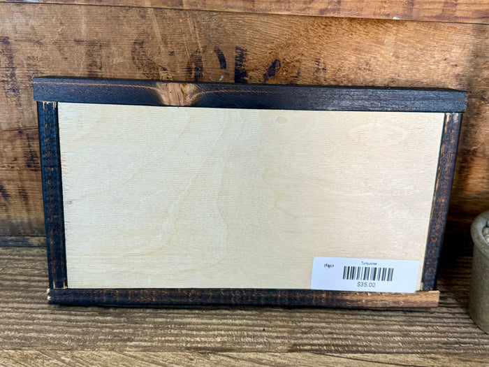 Wood framed wall art back with blank white panel and shipping label.