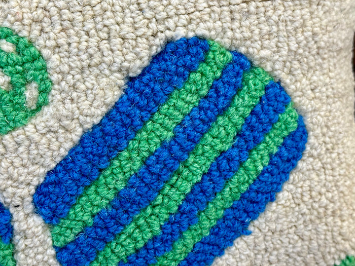 Hand-hooked wool pillow detail: blue and green striped pickleball paddles on cream