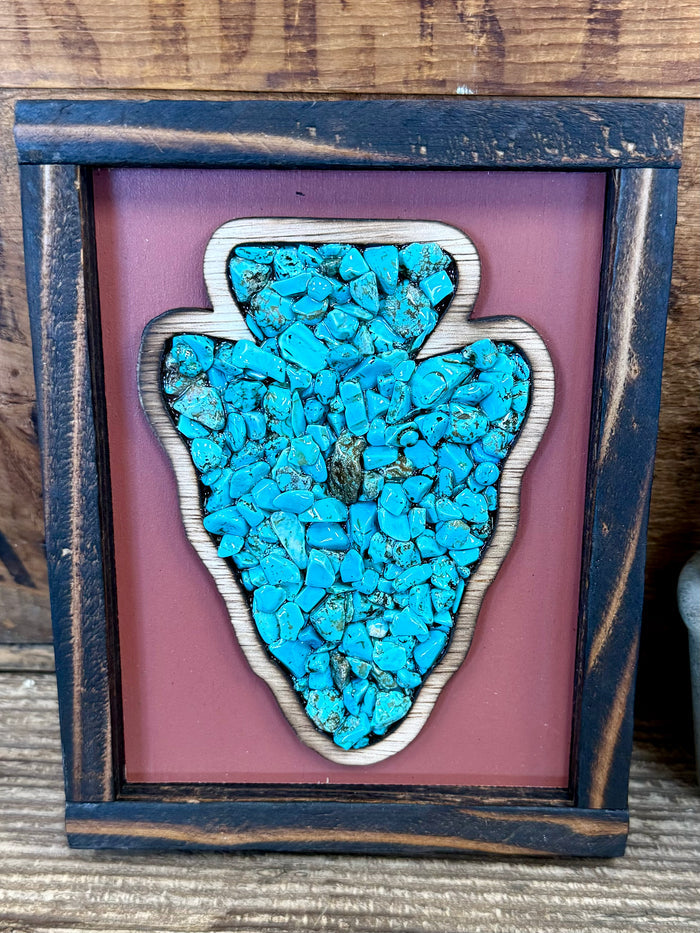 Turquoise arrowhead art in dark wood frame, teal stone chips filling arrow shape