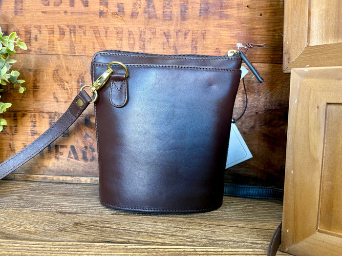 Brown leather bucket purse with zip top and adjustable crossbody strap, gold hardware