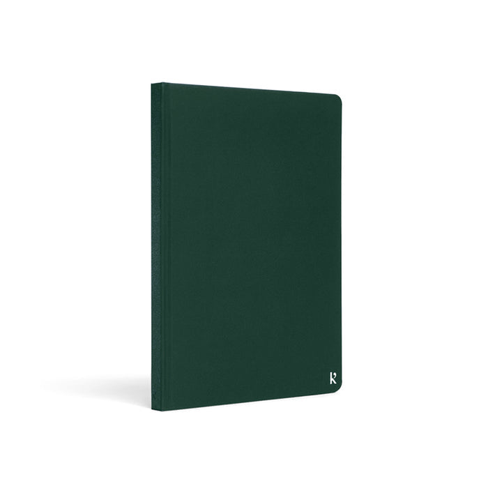 Karst A5 Stone Paper Notebook in forest green with hard cover, shown at an angled view on a light gray background.