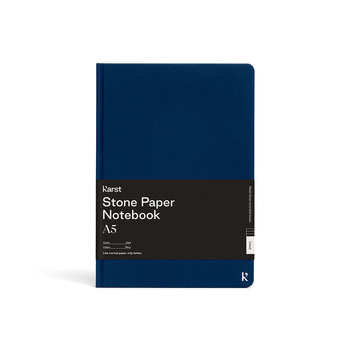 Karst A5 Stone Paper Notebook in navy blue with hard cover and black branded belly band, displayed on a light gray background.