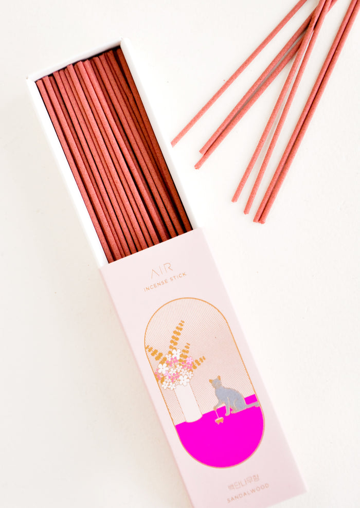 Pink box slid open with incense sticks scattered to the side