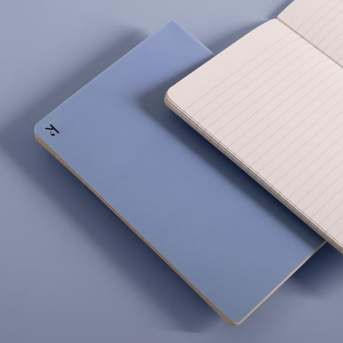 Two notebooks, one blue and one white with grid pattern, on a light blue background.
