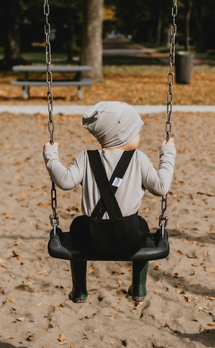 Soft and stretchy taupe beanie for kids, made from eco-friendly fabric. Ethically crafted in Canada, featuring a fold-over brim and minimalist design