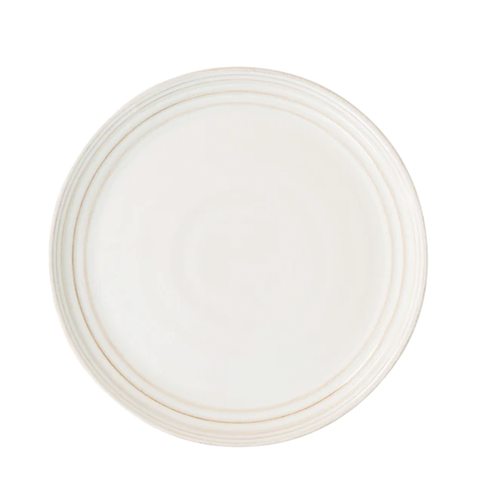 A white ceramic dinner plate with a subtle textured rim.