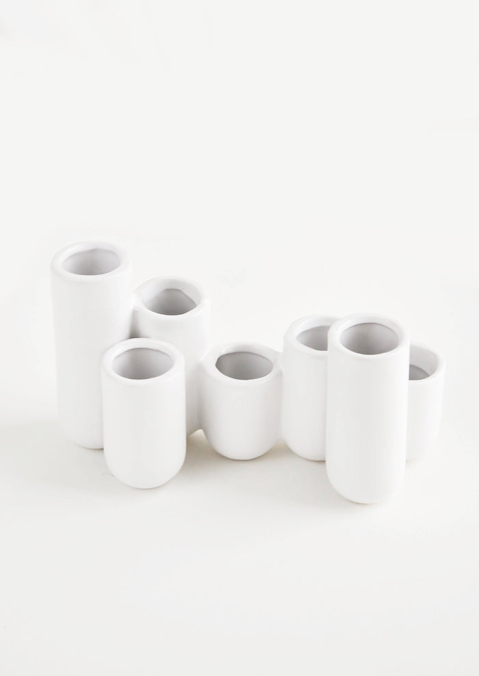 Multiple stem vase made of white ceramic vials in varying heights, clustered and fused together