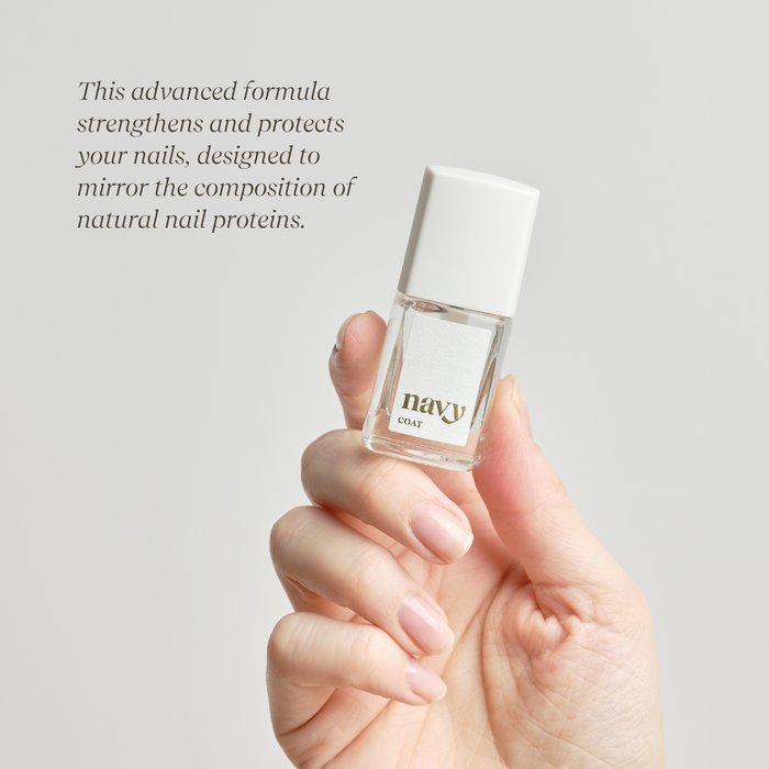 Hand holding a small bottle of nail polish with text about nail strength and protection.