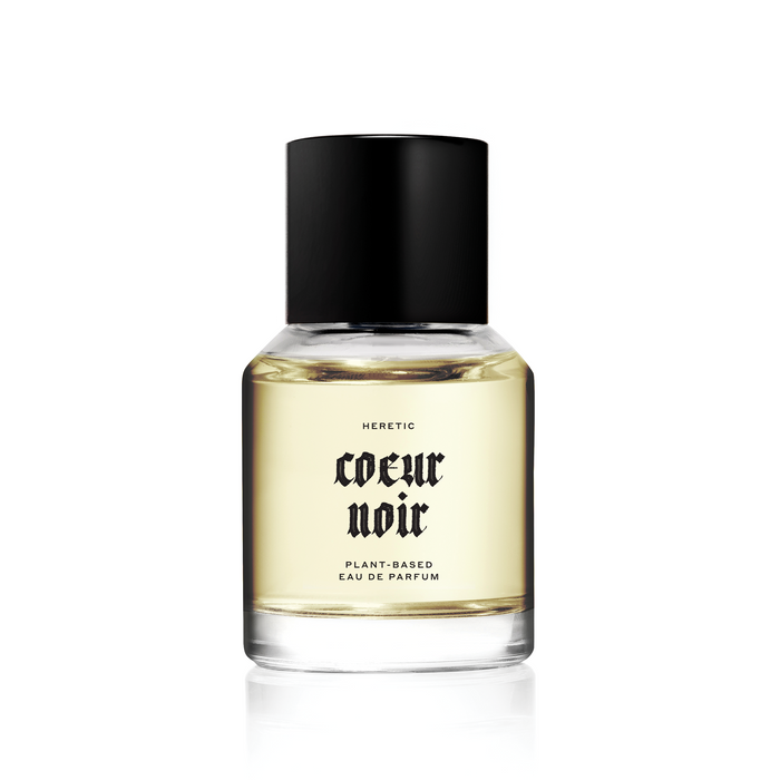 A clear bottle of 'Coeur Noir ' perfume by Heretic with a black cap, label indicating "plant-based parfum"