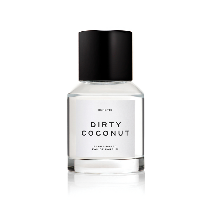 A clear glass bottle with a black cap of 'Dirty Coconut' by HERETIC Perfume, other text: plant-based fragrance.