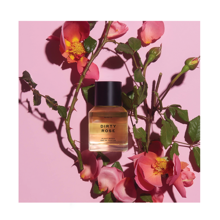 Styled product flatlay of Heretic 'Dirty Rose' Perfume on a pink background surrounded by roses