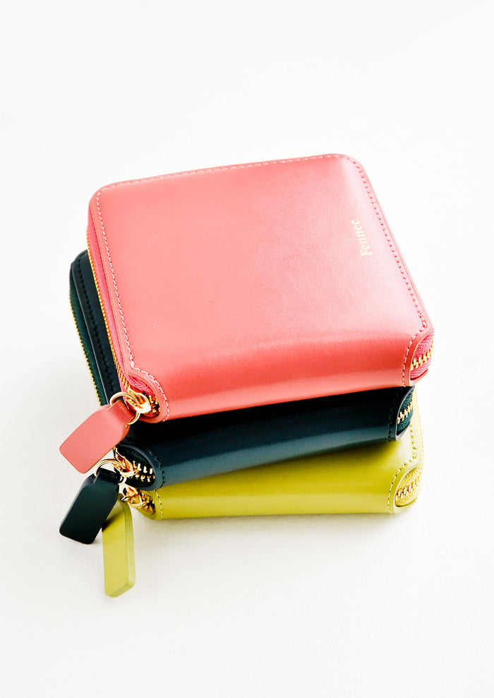 Product show showing multiple colors of zip wallets in a stack.