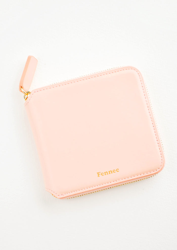 Light pink leather wallet that zips on three sides, with matching tab pull.