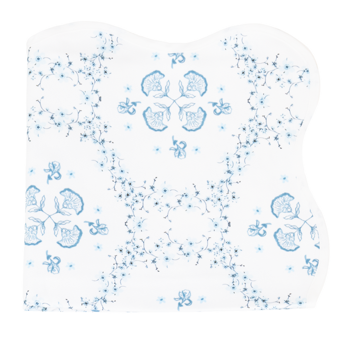 A white tablecloth with a floral trellis pattern in blue.
