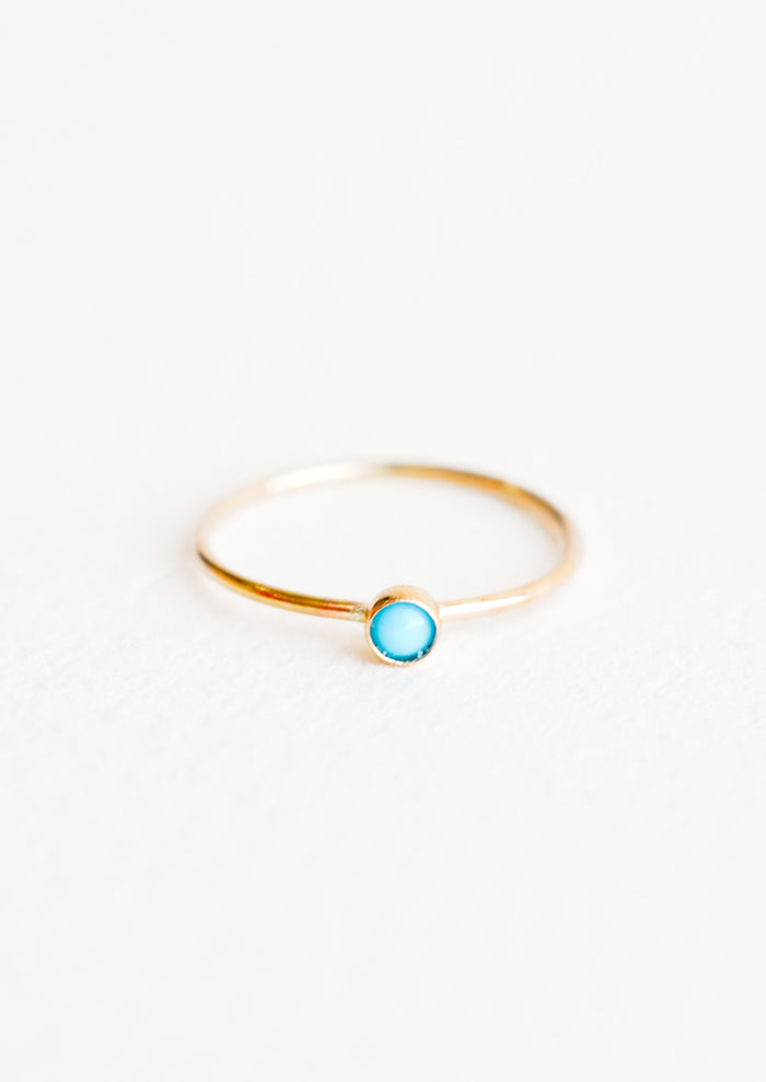 Yellow gold ring with slim band and small blue turquoise stone.