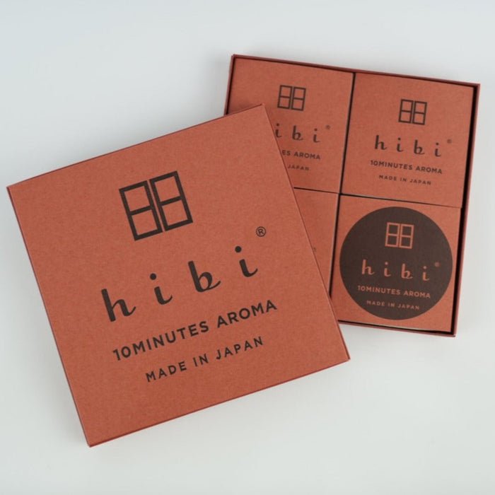 A hibi 10 Minutes Aroma incense match gift set on a white background, featuring a brown hibi box lid in the foreground and an open box behind it with four matching brown inner boxes arranged in a grid.