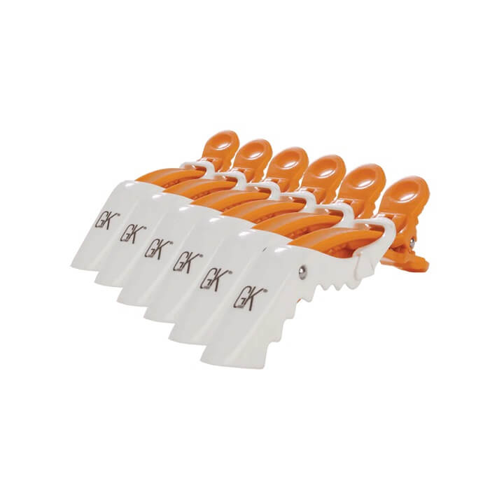 GK Hair Shark Clips six-pack, orange hinged jaws and a silver hinge rivet behind the row of white GK-branded paddles, on white