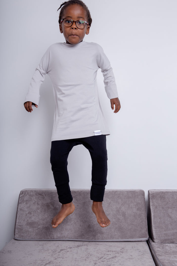Black grow-with-me pants for toddlers and kids, made from soft, eco-friendly fabric. Adjustable waistband and cuffs for extended wear. Ethically made in Canada.