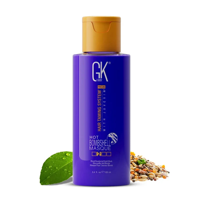 GK Hair Hot Bombshell Masque 100 ml purple bottle with gold cap, labeled Blond Bombshell Hold Mask, beside a leaf and seeds