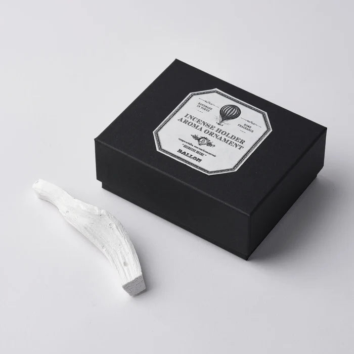 A white marble incense holder next to its black packaging box, which has a label that reads 'INCENSE HOLDER MARBLE'.