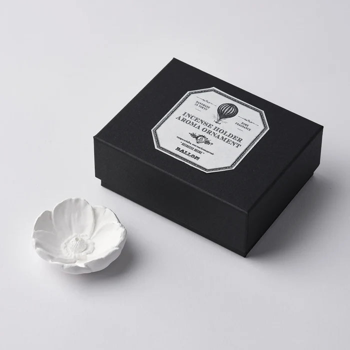 A white marble incense holder next to its black packaging box, which has a label that reads 'INCENSE HOLDER MARBLE'.