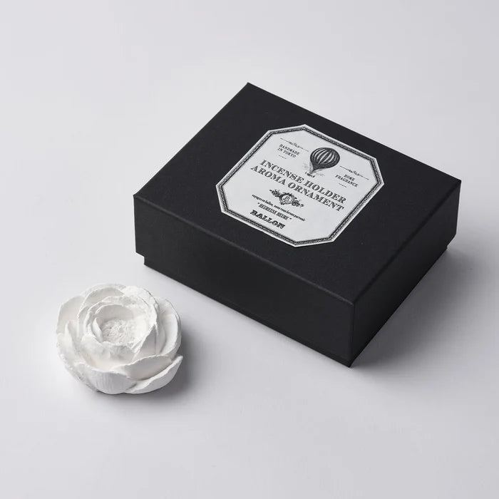 A white marble incense holder next to its black packaging box, which has a label that reads 'INCENSE HOLDER MARBLE'.