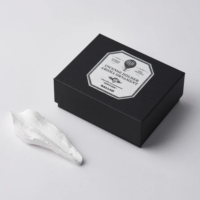 A white marble incense holder next to its black packaging box, which has a label that reads 'INCENSE HOLDER MARBLE'.