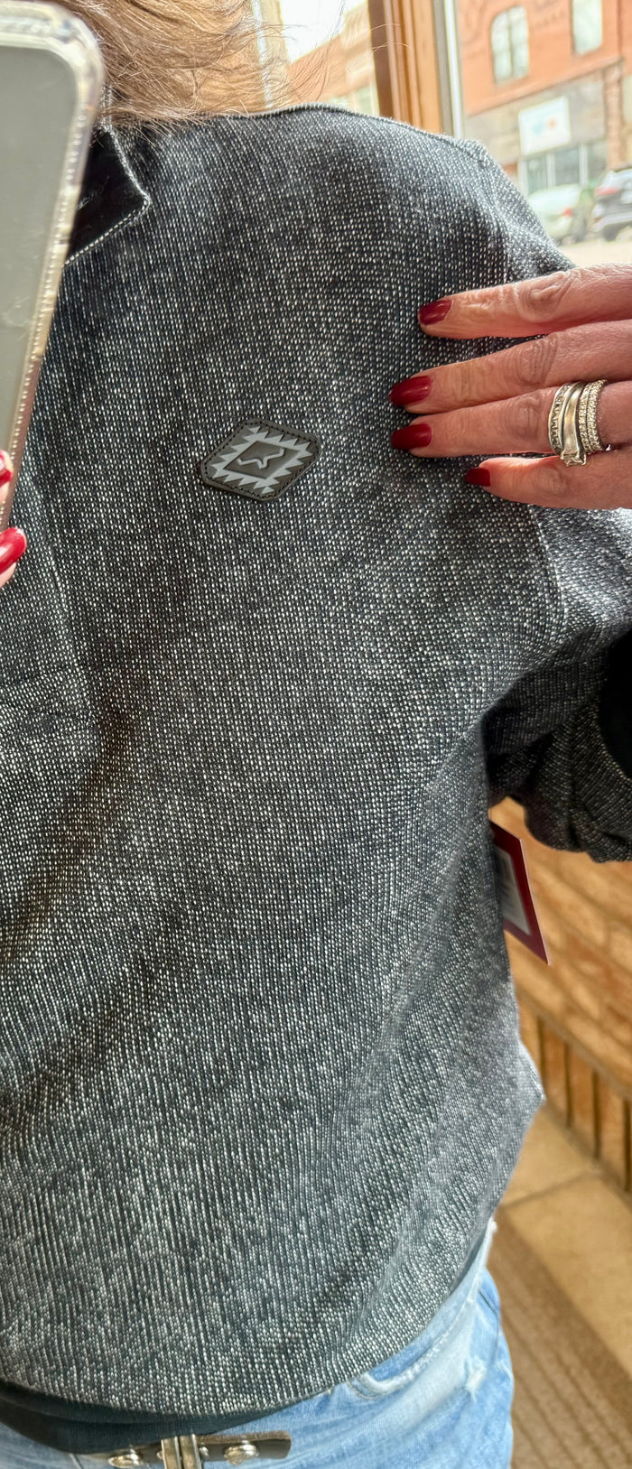 Charcoal heather gray sweatshirt close-up with logo patch on chest, mock neck