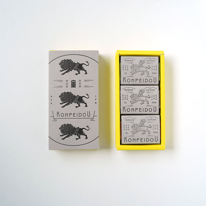 A set of three matchboxes from the brand KOMPEIDOU, displayed on a clean white background. The set includes one closed matchbox with a gray cover featuring a black illustration of a lion and the brand name, and an open yellow tray containing three individual matchboxes with gray covers.