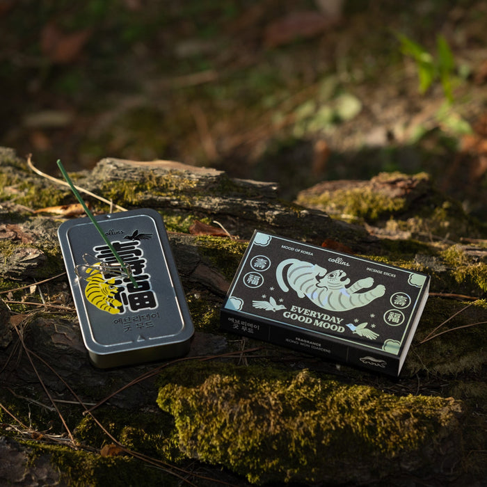 Korean incense stick tin and “Everyday Good Mood” incense box displayed on moss-covered wood, natural outdoor product scene with calming fragrance and ritual lifestyle aesthetic.