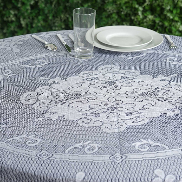 Decorative tablecloth on a dining table set with glass and plate.