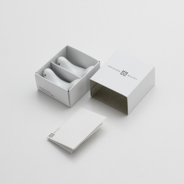 White gift box set containing two white bird-shaped ceramic chopstick rests with branded packaging and insert card, displayed on a clean neutral background in a minimalist product presentation.